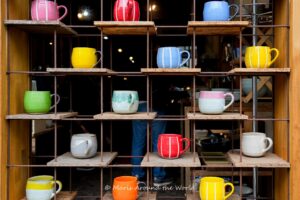 Display of coloful ceramic mugs.
