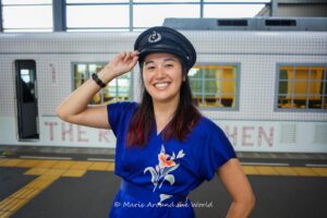 Girl in hat in front of train.